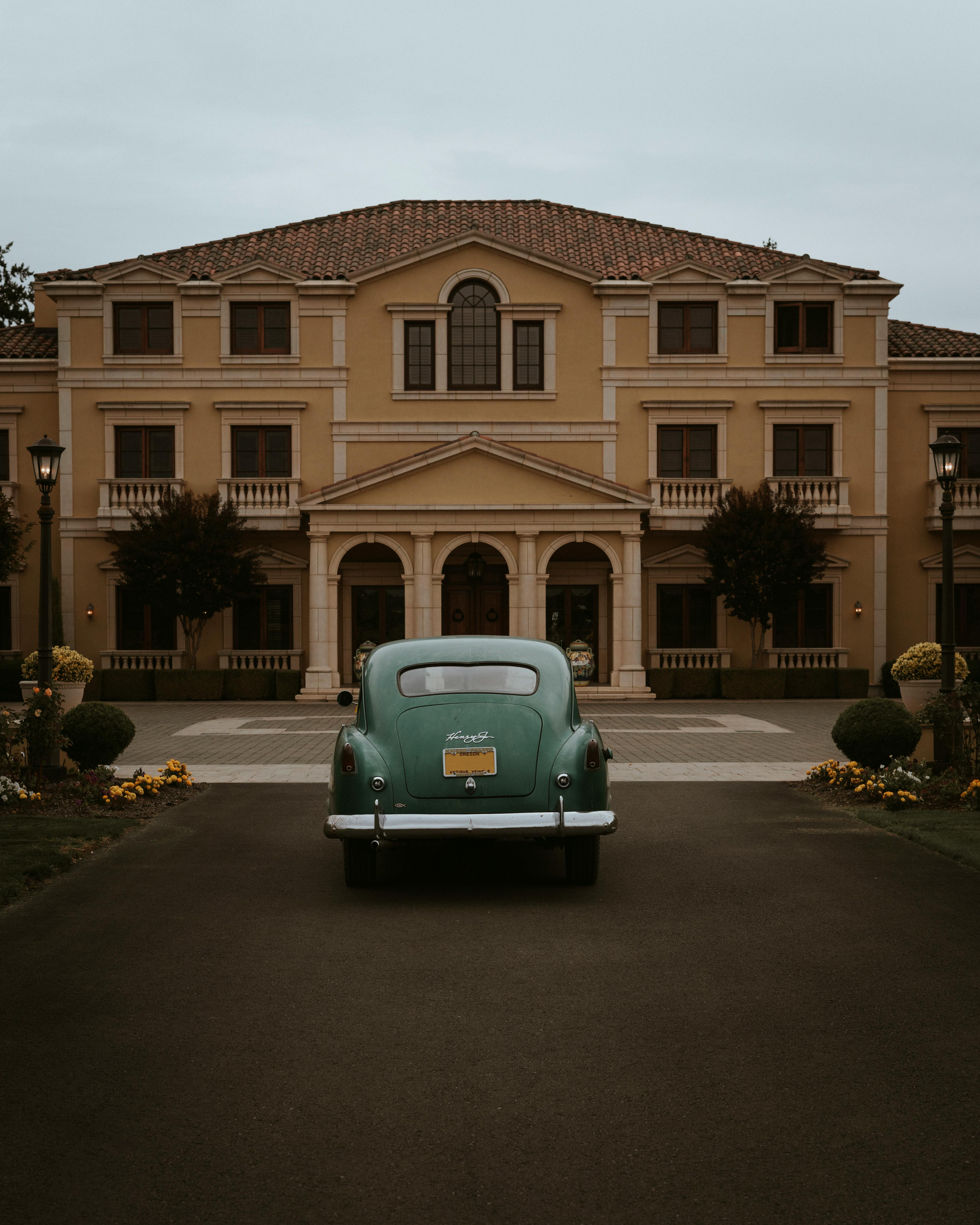 Classic vintage car parked in front of an elegant mansion in Portland, Oregon.
